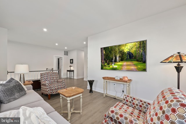 living room featuring baseboards, wood finished floors, visible vents, and recessed lighting