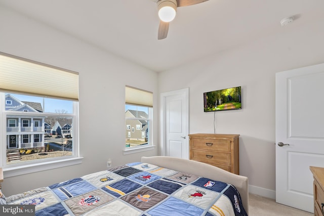 bedroom featuring ceiling fan, baseboards, and light carpet