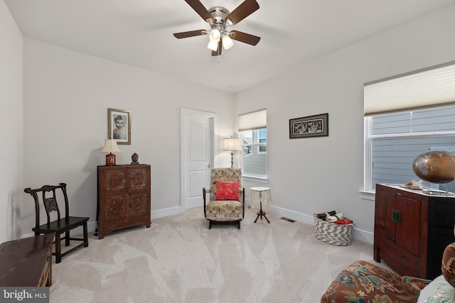 living area featuring visible vents, a ceiling fan, baseboards, and carpet floors