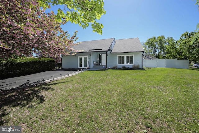 view of front of house featuring french doors, fence, and a front yard