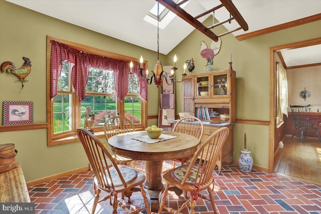 dining space with baseboards, an inviting chandelier, lofted ceiling with skylight, and brick floor