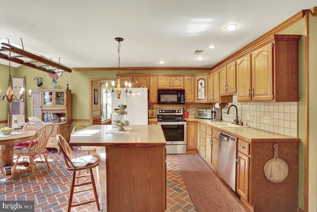 kitchen featuring an inviting chandelier, a sink, visible vents, brick floor, and appliances with stainless steel finishes