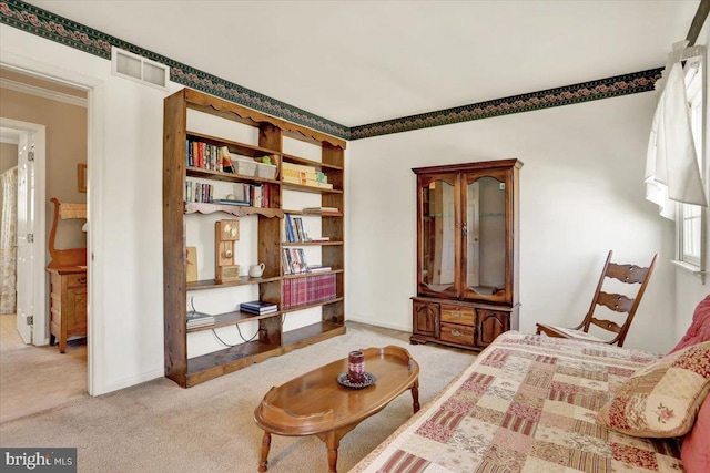living area with baseboards, visible vents, ornamental molding, and carpet