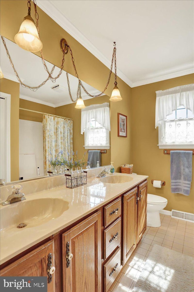 full bath featuring tile patterned floors, double vanity, crown molding, and a sink