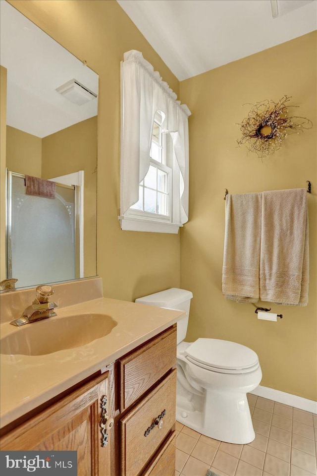 full bath with vanity, tile patterned floors, toilet, a stall shower, and baseboards