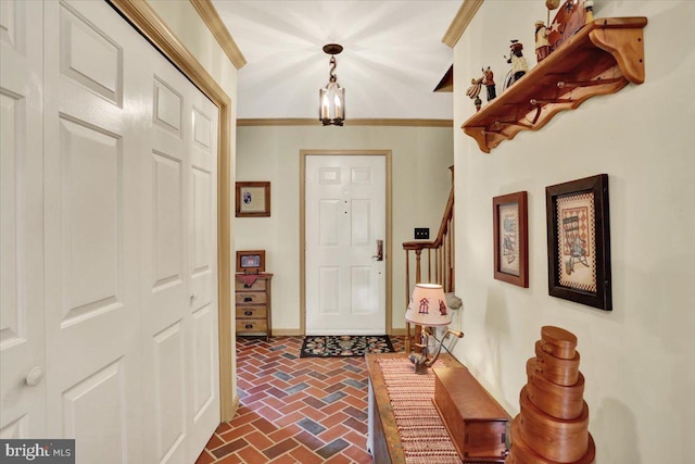 entryway with baseboards, ornamental molding, brick floor, and stairs