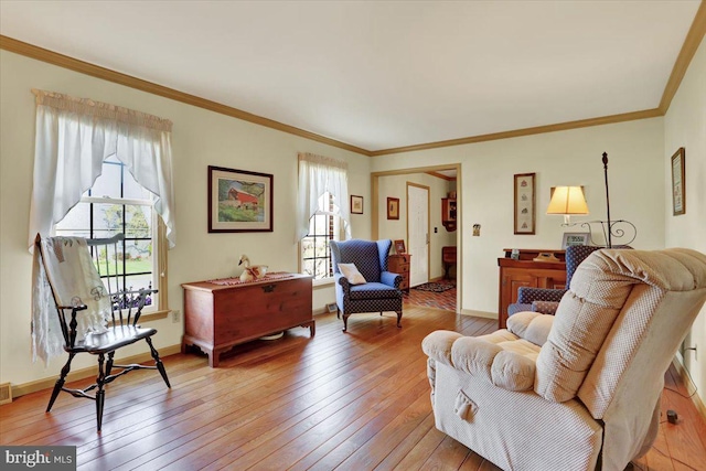 living area with crown molding, light wood-style floors, and plenty of natural light