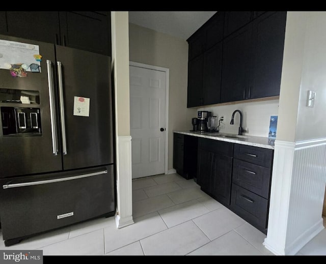 kitchen with a sink, light countertops, dark cabinetry, and high quality fridge
