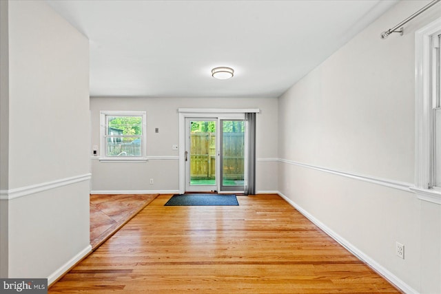 doorway to outside with wood finished floors and baseboards