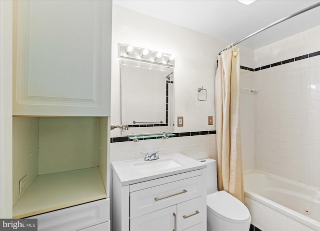 full bathroom with tile walls, vanity, toilet, and shower / tub combo with curtain