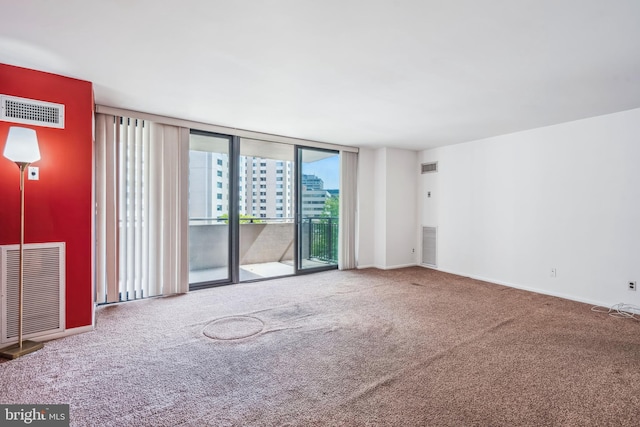 carpeted empty room featuring visible vents and baseboards