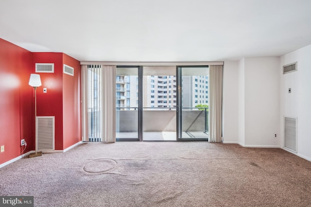 carpeted spare room featuring visible vents