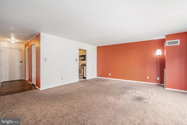 unfurnished living room featuring visible vents, carpet flooring, and baseboards