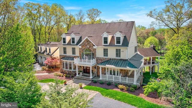 12205 Thoroughbred Rd, Oak Hill, VA 20171 - view of front of property with a garage, a balcony, stone siding, a standing seam roof, and a porch