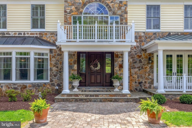12205 Thoroughbred Rd, Oak Hill, VA 20171 - doorway to property with stone siding, french doors, a balcony, a standing seam roof, and metal roof