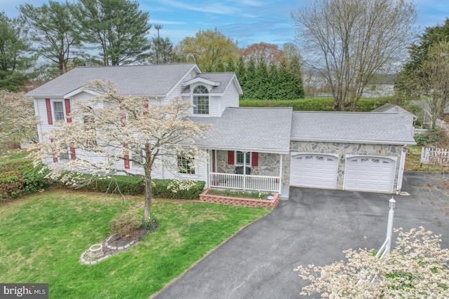 view of front of property featuring a front lawn, driveway, stone siding, an attached garage, and roof with shingles