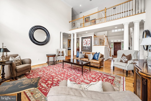13543 Rustling Oaks Dr, Wye Mills, MD 21679 - living area featuring decorative columns, a high ceiling, wood finished floors, baseboards, and crown molding