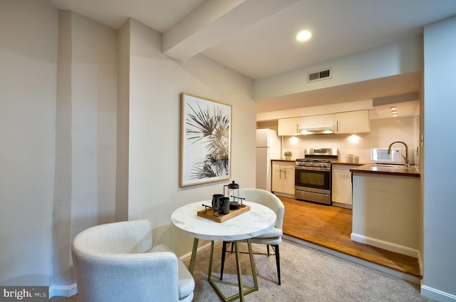 dining space featuring baseboards, light wood finished floors, and visible vents