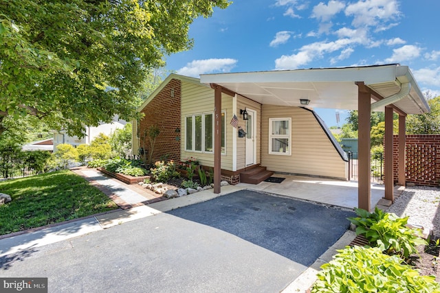 5511 Gwyn Pl, Alexandria, VA 22312 - view of front of home with entry steps, an attached carport, asphalt driveway, and fence