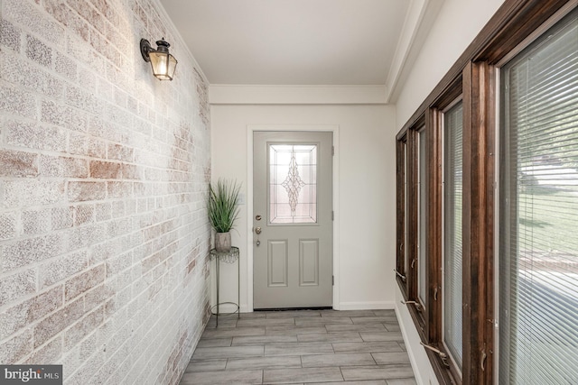 5511 Gwyn Pl, Alexandria, VA 22312 - doorway to outside featuring brick wall, crown molding, an accent wall, and baseboards