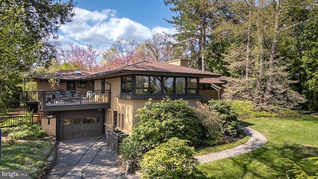715 W Park Ave, State College, PA 16803 - exterior space featuring a balcony, concrete driveway, a lawn, an attached garage, and stucco siding