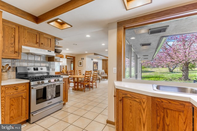 715 W Park Ave, State College, PA 16803 - kitchen featuring under cabinet range hood, light countertops, a sink, light tile patterned flooring, and stainless steel gas range