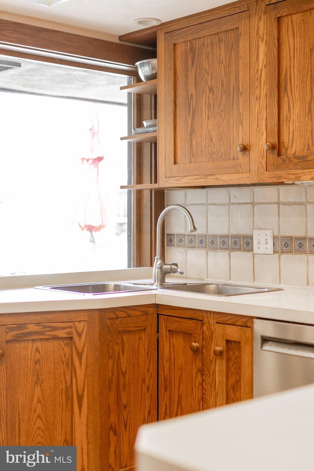 715 W Park Ave, State College, PA 16803 - kitchen featuring brown cabinetry, stainless steel dishwasher, light countertops, and a sink
