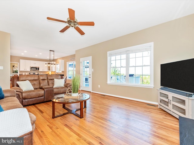 living room with visible vents, baseboards, ceiling fan, recessed lighting, and light wood-type flooring