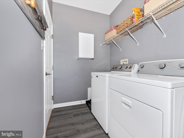 laundry area with baseboards, laundry area, dark wood-style floors, and washer and clothes dryer