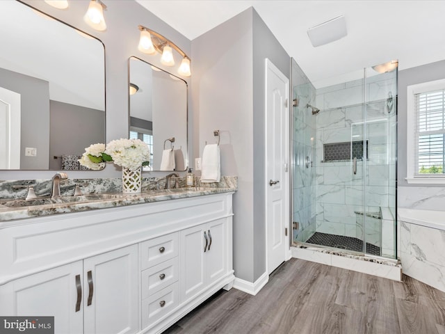 bathroom with double vanity, baseboards, a marble finish shower, and a sink