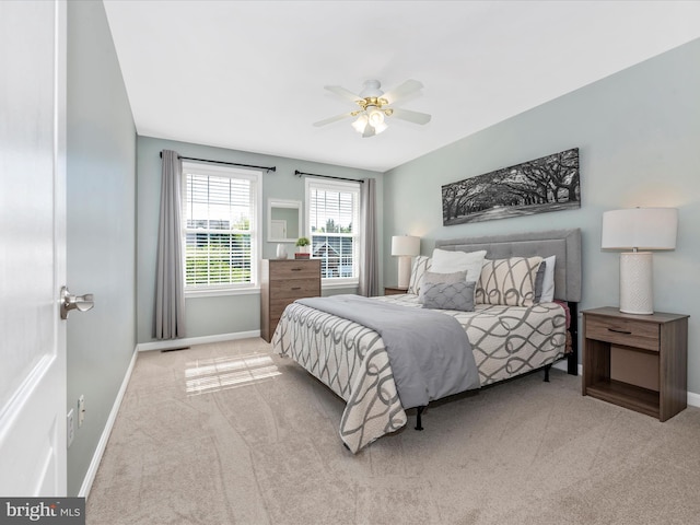 carpeted bedroom with baseboards, visible vents, and ceiling fan