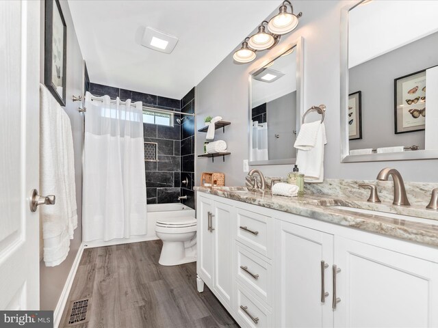bathroom featuring visible vents, a sink, wood finished floors, and toilet