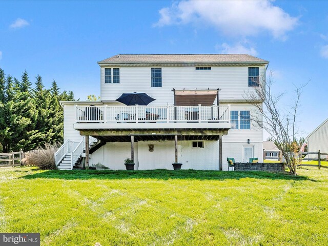 back of property featuring a lawn, a deck, fence, and stairs