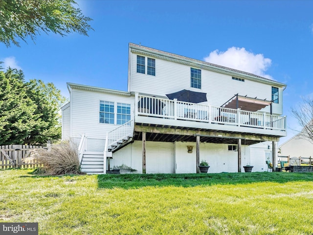 back of property with a lawn, a wooden deck, and stairs