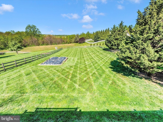 view of yard featuring fence and a rural view