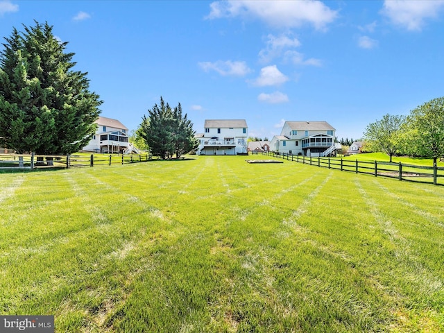 view of yard featuring a rural view and fence