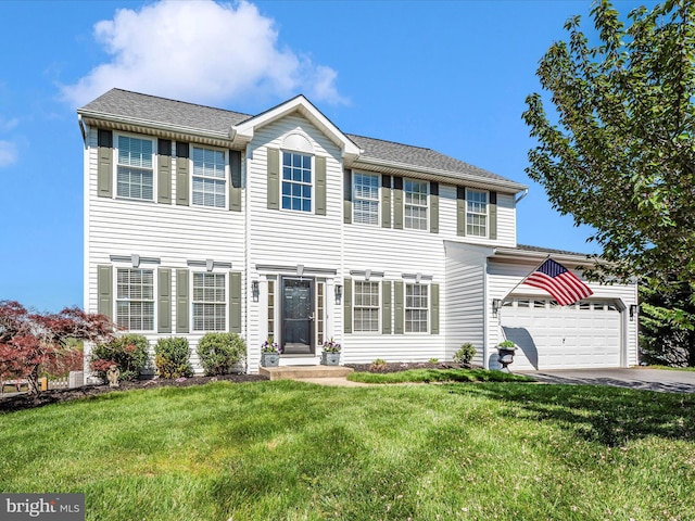colonial home featuring an attached garage, driveway, and a front lawn