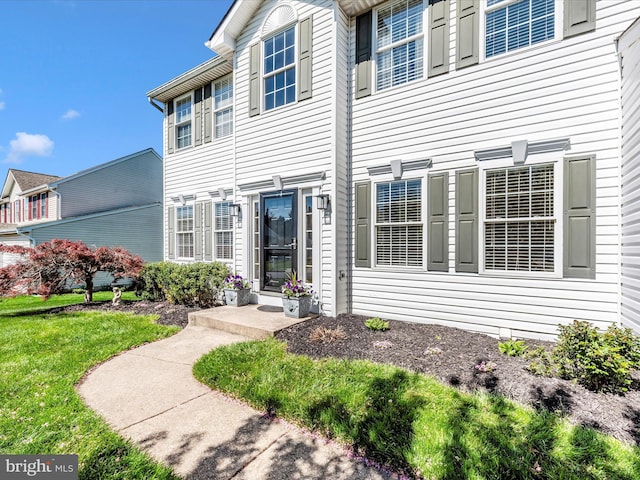 doorway to property featuring a lawn