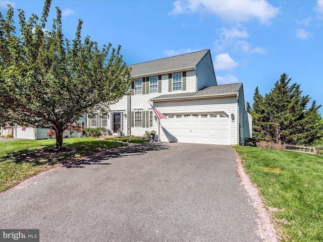view of front of property featuring roof with shingles, driveway, and a front yard