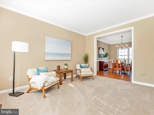 living area with baseboards, ornamental molding, carpet, and a notable chandelier