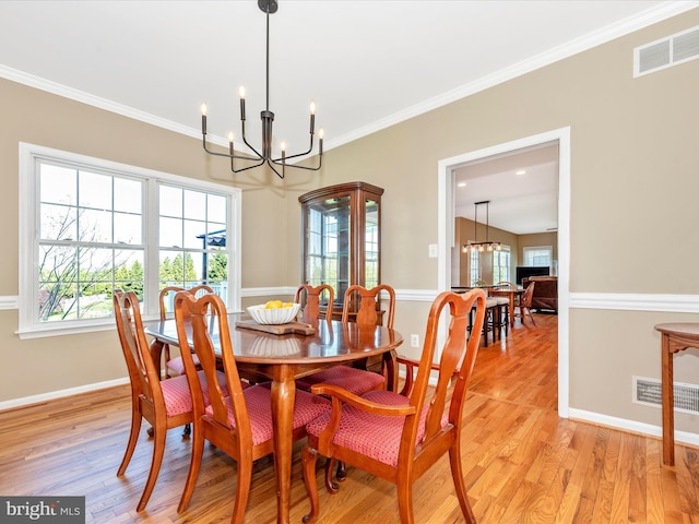 dining area with an inviting chandelier, plenty of natural light, visible vents, and light wood-type flooring