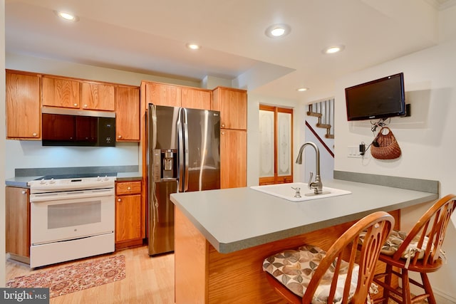 kitchen featuring a kitchen breakfast bar, stainless steel refrigerator with ice dispenser, white electric range, a sink, and a peninsula