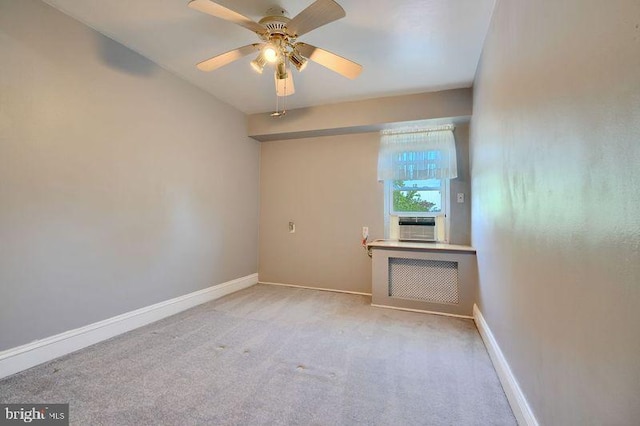 spare room with baseboards, ceiling fan, carpet, and radiator