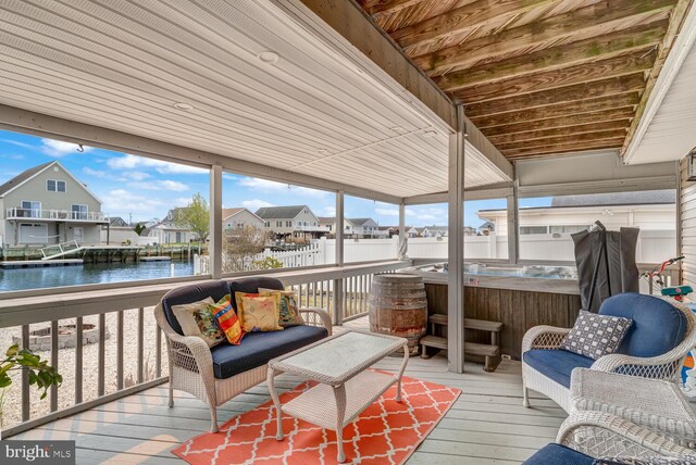 sunroom / solarium with outdoor lounge area, a jacuzzi, a residential view, and a water view