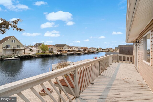 view of dock with a residential view and a deck with water view