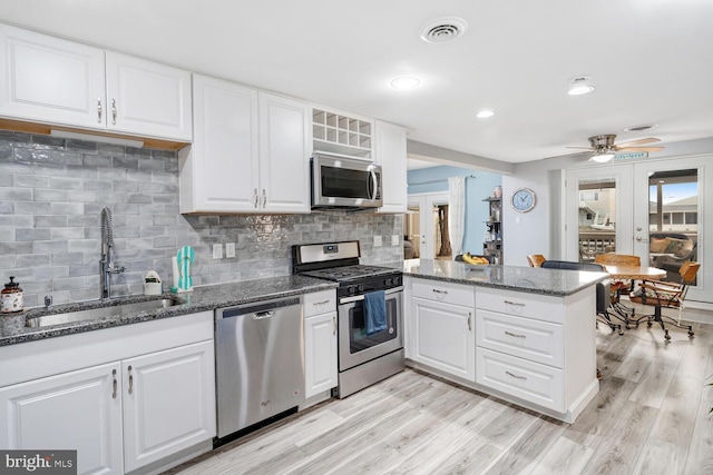 kitchen featuring a sink, ceiling fan, visible vents, stainless steel appliances, and a peninsula
