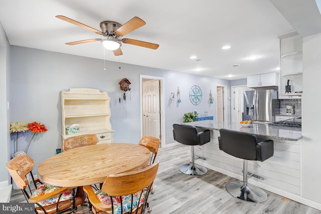 dining space featuring light wood finished floors, recessed lighting, ceiling fan, and baseboards