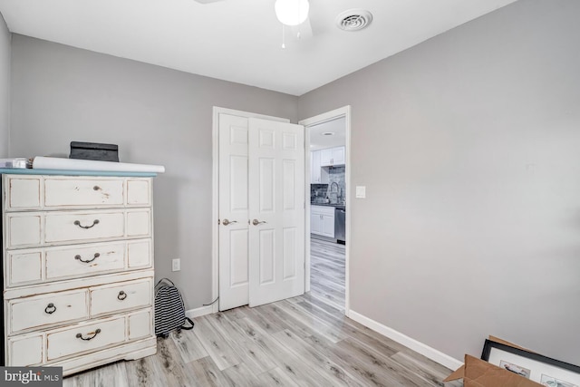 bedroom featuring a sink, visible vents, baseboards, and light wood-style floors