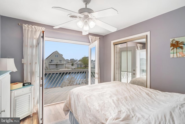 bedroom with wood finished floors, ceiling fan, access to outside, and a closet