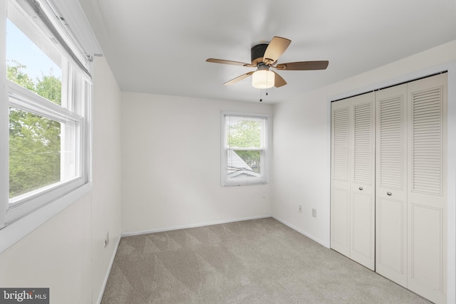 unfurnished bedroom featuring baseboards, a closet, ceiling fan, and carpet